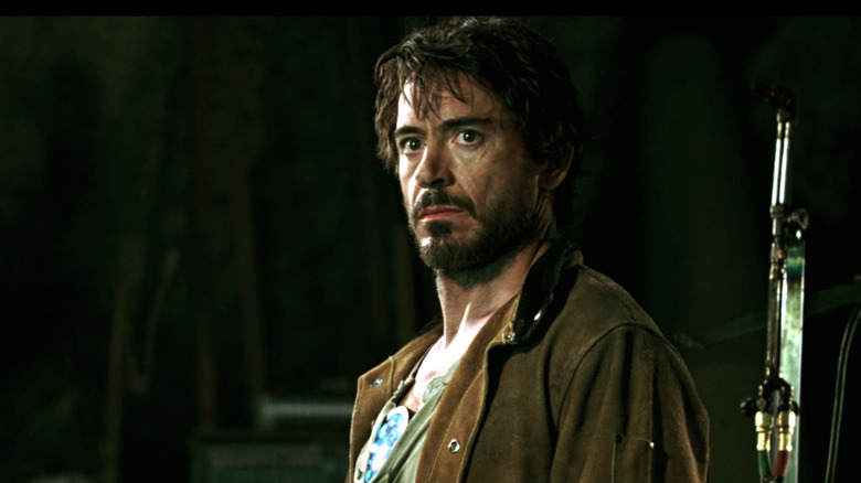 Tony Stark looking worried as a captive with overgrown hair and beard 